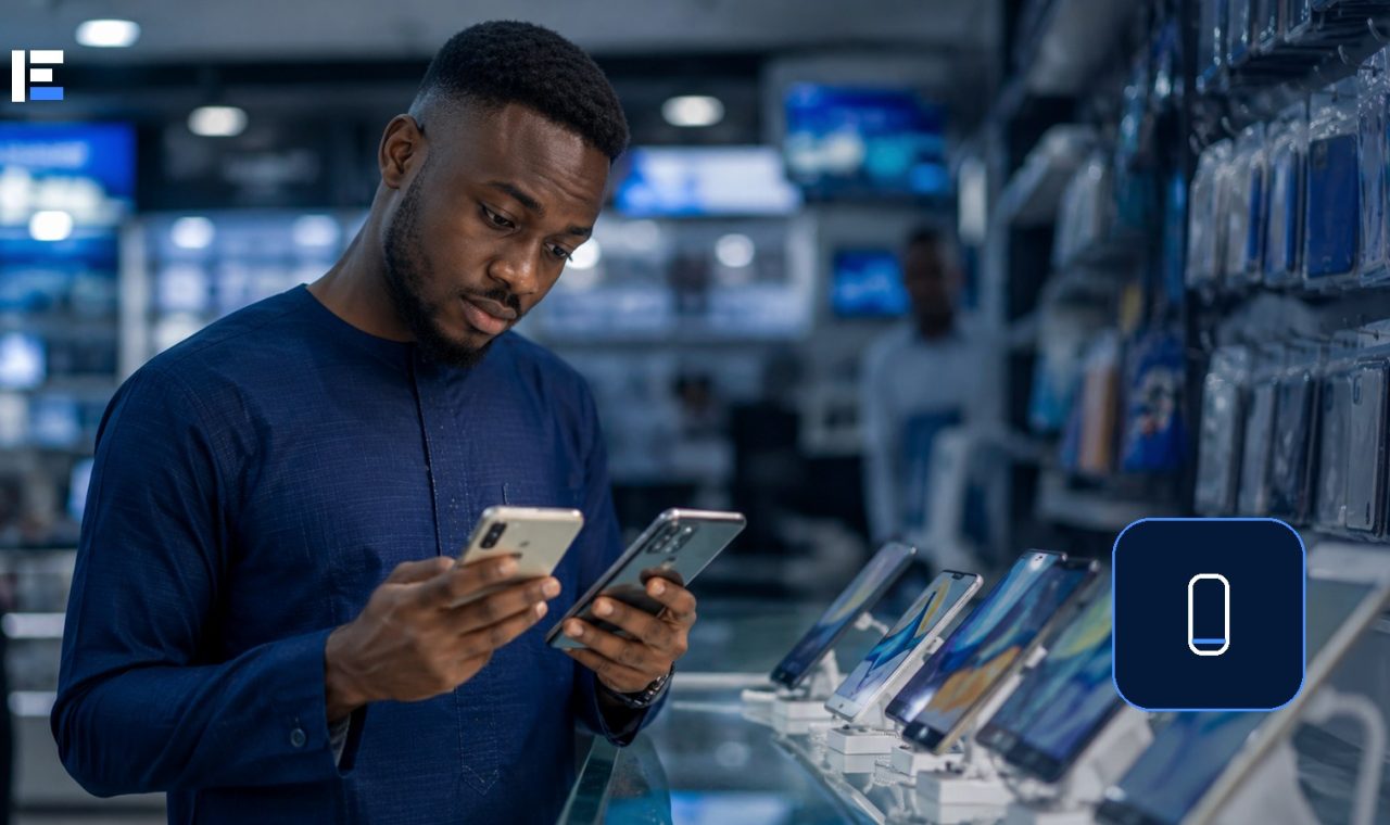 A shopper comparing two smartphones in a Nigerian electronics store