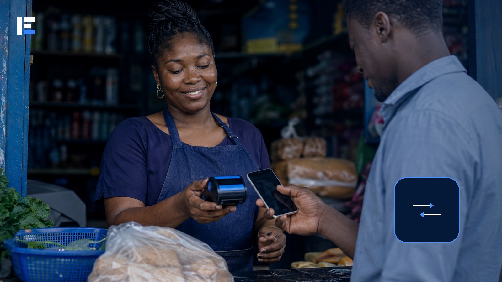 A Nigerian market customer completing a digital payment with a mobile phone