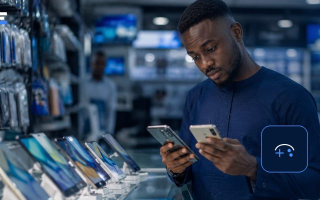 A Nigerian shopper comparing smartphones for mobile gaming in an electronics store